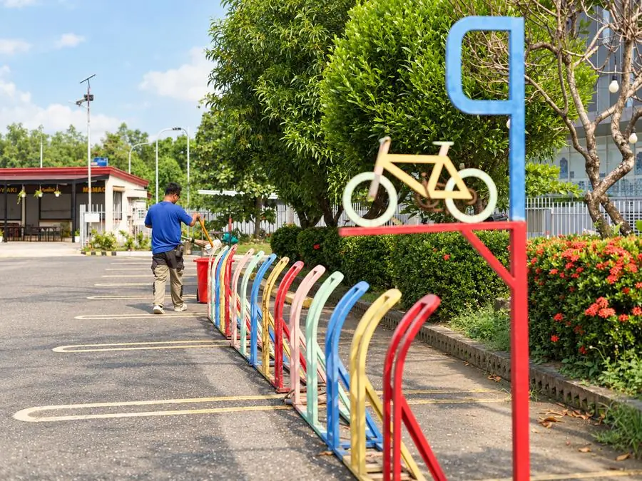 A rainbow-colored bike rack with a bicycle sign